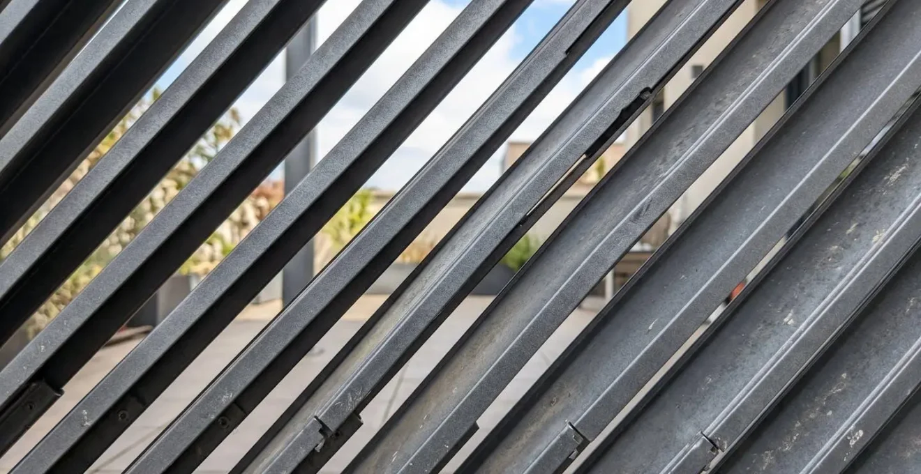 Gros plan sur lames orientables en aluminium d'une pergola bioclimatique avec espacement de ventilation visible